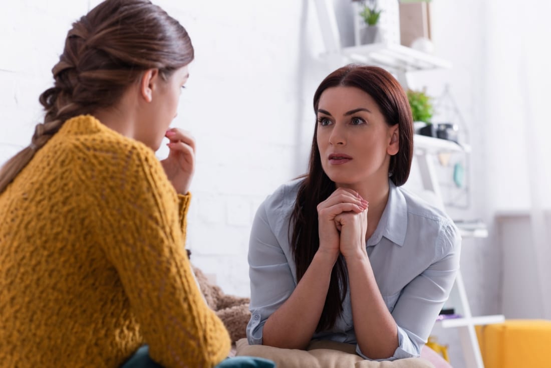 Worried parent and daughter discussing scoliosis diagnosis
